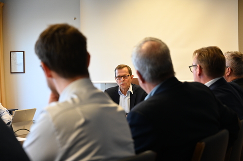Mekler Bjørn Lillebergen leder møtet, sett mellom omrisset av flere andre møtedeltakere